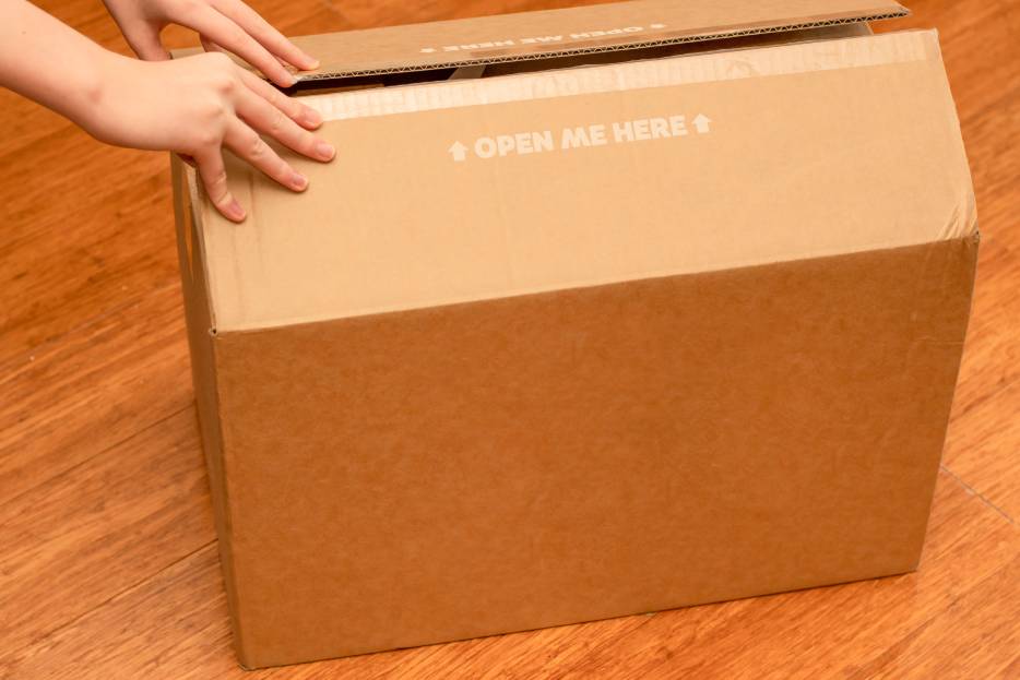 persona abriendo caja de cartón